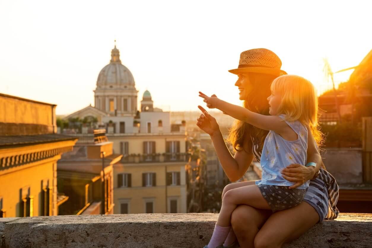 Mère et bébé fille assis dans la rue de Rome - Où partir seule avec un enfant ? Les 12 meilleures destinations pour les mamans solos et leur(s) enfant(s) !