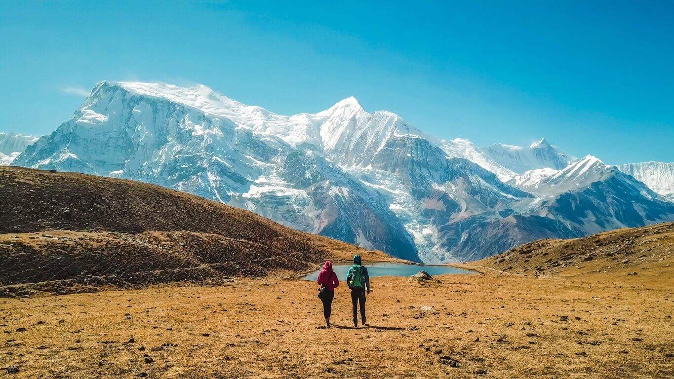 Népal couple et le lac de glace avec la vue sur la chaîne de lAnnapurna - Les 20 plus beaux pays du monde : à visiter de toute urgence !