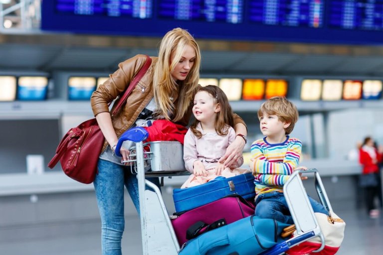 Little girl and boy and young mother with suitcases