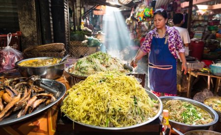 Image of a Khmer rural women in the countryside selling street food in a open market in Cambodia.