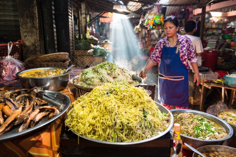 Image of a Khmer rural women in the countryside selling street food in a open market in Cambodia.