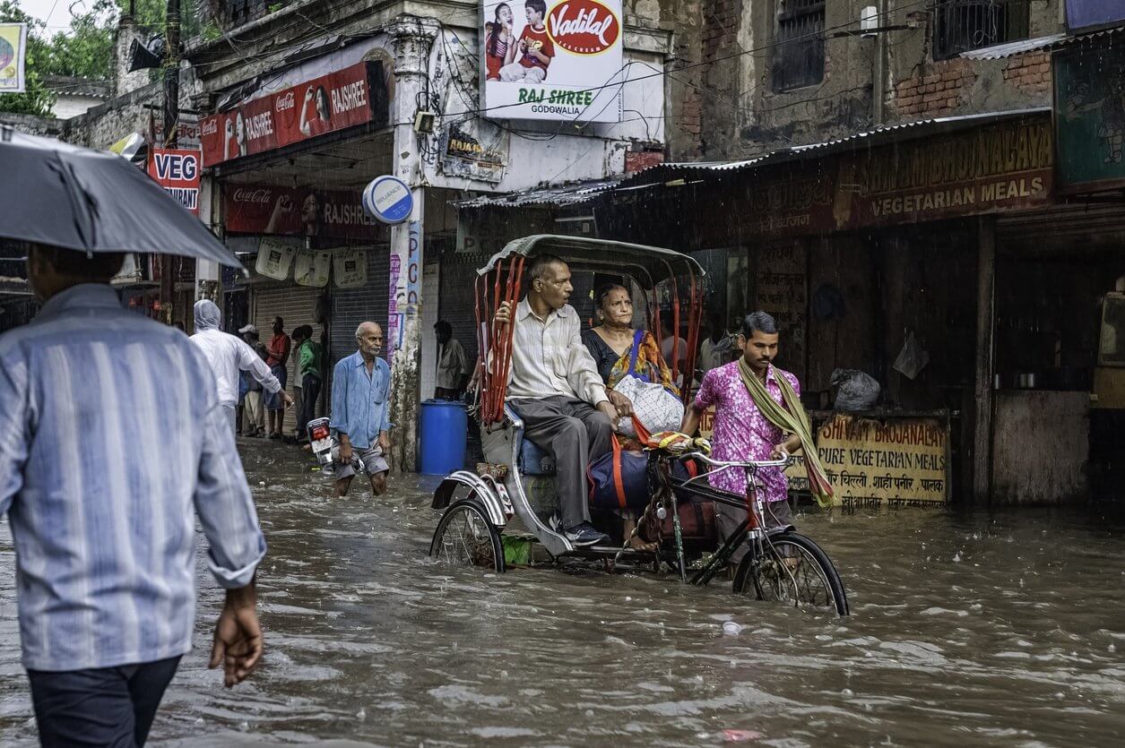 Voyager en Inde pendant la mousson : voyage magique ou galères en perspectives ? 4 Pousse-pousse et les passagers de négocier une inondation, Varanasi, Inde.
