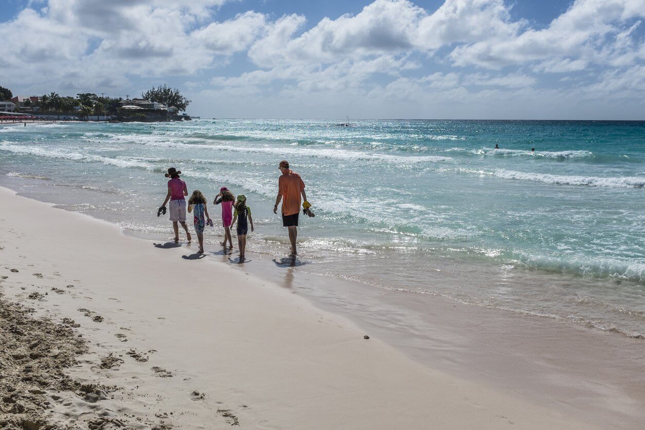 Les 15 meilleures îles à visiter en famille 12 Family walking on a beach, Barbados
