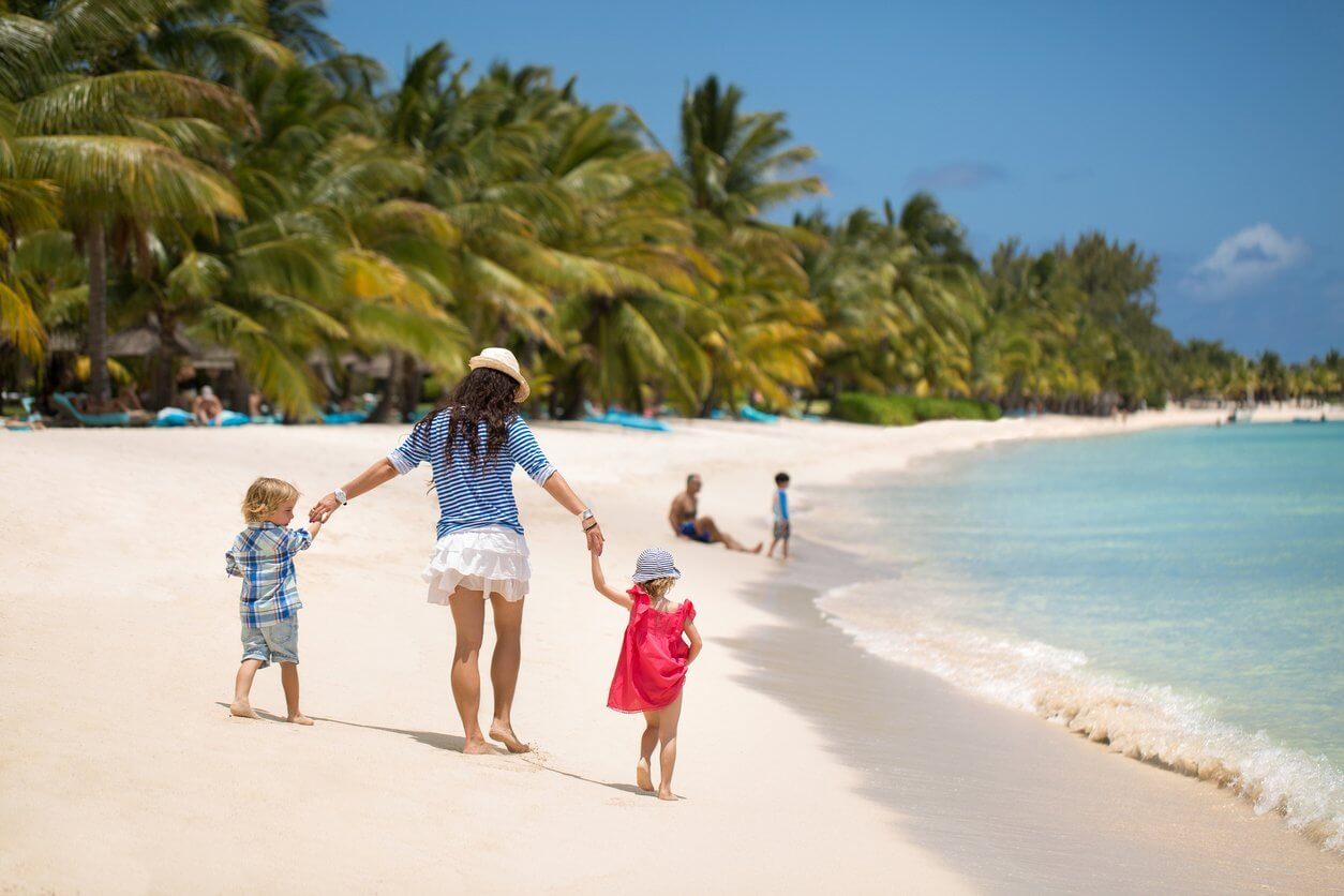Les 15 meilleures îles à visiter en famille 2 Beautiful mother, son and daughter walking on the beach of the Indian ocean.
