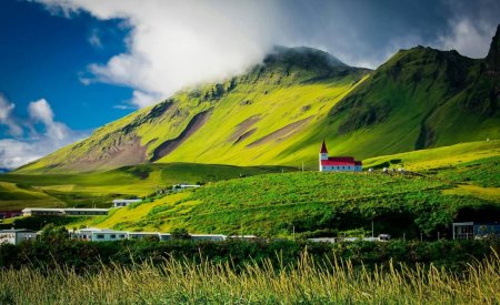 green field near mountain during daytime