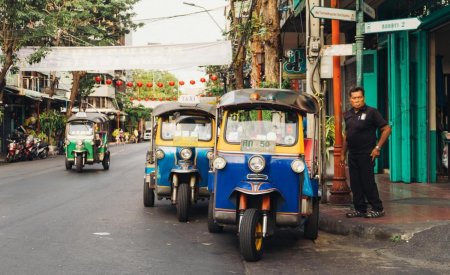 man standing beside parked trikes